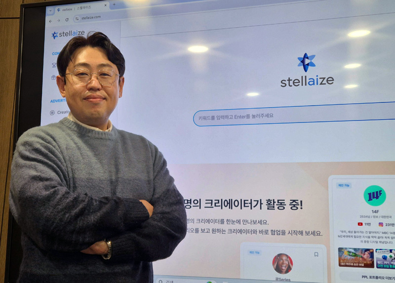 스텔라이즈 첫 화면을 배경으로 원정환 인크로스 AI신성장본부장이 포즈를 취하고 있습니다.